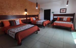 巴耶斯城Kali Huasteca Posada的酒店客房带两张床和长凳