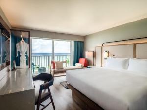 塔穆宁关岛皇冠假日度假酒店的酒店客房设有一张大床和一个阳台。
