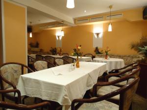 马尔欣马库斯酒店及餐厅的用餐室配有桌椅和白色桌布