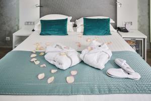 安锡阿讷西卡尔顿贝斯特韦斯特酒店的床上有毛巾和鞋子,还有鲜花