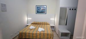 利多克拉西Hotel Zeus Lido di Classe Room Only的小房间设有一张床和一台冰箱
