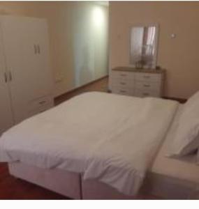 阿吉曼Lemas 901的卧室配有白色的床和梳妆台。