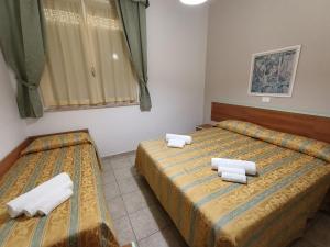 利多克拉西Hotel Zeus Lido di Classe Room Only的客房内的两张床和毛巾