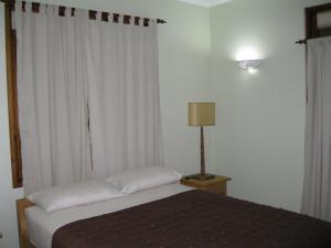 普拉兰大安塞区卡萨沃尔德酒店的一间卧室配有床、灯和窗帘