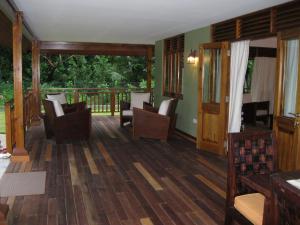 普拉兰大安塞区卡萨沃尔德酒店的一间带木地板和椅子的客厅以及一个阳台