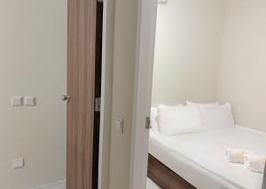 新加坡Hotel Calmo Chinatown的一间卧室配有带白色床单和枕头的床。