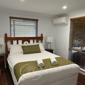 卡尔巴里Seashells Holiday House - Kalbarri的一间卧室配有一张床,上面有两条毛巾