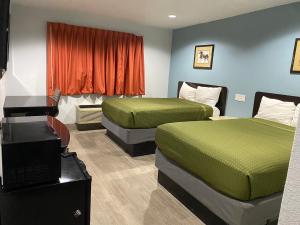霍布斯Executive Inn的酒店客房设有两张床和电视。
