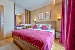 兹拉蒂博尔Apartman 65 Zlatibor的一间卧室配有一张大床和紫色毯子