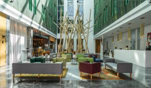 迪拜Al Khoory Courtyard Hotel的大楼内带桌椅的大堂