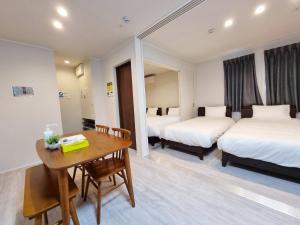 东京PRISM Inn Kamata的酒店客房设有两张床和一张木桌。