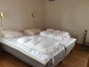 霍伊斯莱乌Lundø的配有两张未铺好床铺的白色床单和枕头