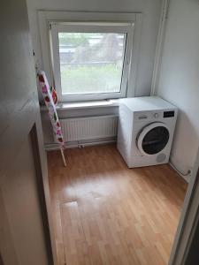 鹿特丹Single family home in Hillegersberg - Schiebroek的洗衣房配有洗衣机和窗户