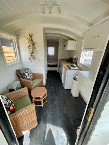 滨海贝亨Pipowagen aan zee的一间小厨房和一间位于小房子内的客厅