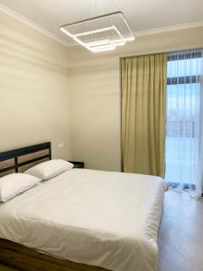 萨克德佐尔镇Uparthotel的卧室设有一张白色大床和一扇窗户。