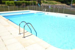 Saint-SylvestreCamping Les Roussilles的庭院里的一个蓝色海水大型游泳池