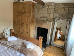 海伯敦桥Meg's Den的一间卧室设有石制壁炉和一张床