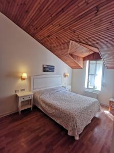 蒙达卡蒙达卡生态酒店的一间卧室设有一张床和木制天花板
