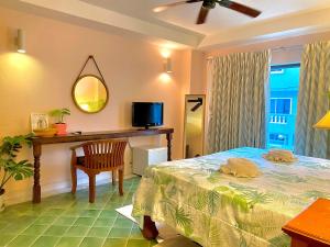 芭东海滩BE Rendez Vous Hotel的一间卧室配有一张床、一张桌子和一台电视