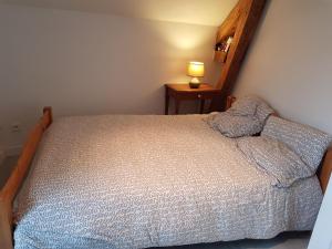 BescatUn petit coin d'OSSAU的一间卧室配有一张床和一张桌子上的台灯