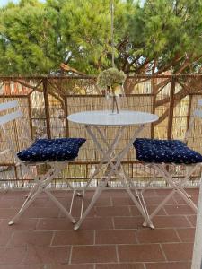皮昂比诺La Casa di Bea的一张带两把蓝色椅子和一张桌子的白色桌子