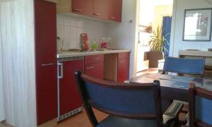 Neu MukranRügen Fewo 284的厨房配有红色橱柜和桌椅
