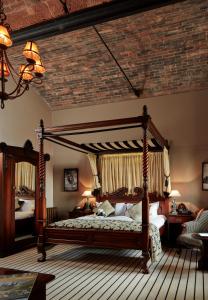 塔博雷Peckforton Castle的卧室配有带砖砌天花板的天蓬床