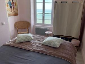 阿罗芒什莱班Appartement de standing - avec terrasse et vue mer的一间卧室设有一张床,享有海景