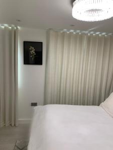 Horndon on the HillA BYK luxury modern home that sleeps 2 - 8 people的卧室配有白色的床和吊灯。