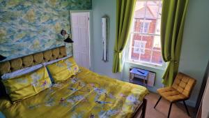 韦茅斯菲儿比奇住宿加早餐旅馆的一间卧室设有黄色的床和窗户。