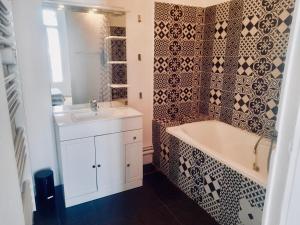 马赛Spacieux et lumineux appartement vue mer Joliette的带浴缸和盥洗盆的浴室