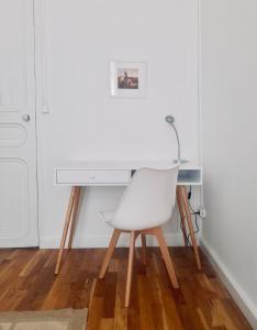 马赛Spacieux et lumineux appartement vue mer Joliette的一张桌子前的白色椅子
