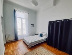 马赛Spacieux et lumineux appartement vue mer Joliette的一间卧室设有一张床和一个大窗户