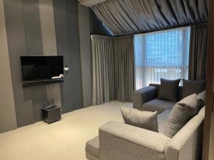 NgabeanOhana Suites Yogyakarta的带沙发和电视的客厅