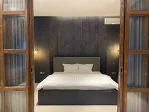 NgabeanOhana Suites Yogyakarta的一间卧室配有一张黑色墙壁的床