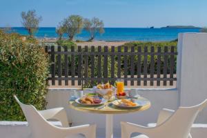Diakofti波尔图迪亚柯福蒂酒店的海滩阳台上的餐桌上摆放着盘子