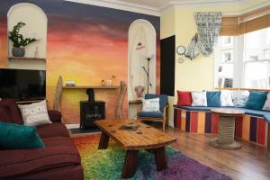 彭赞斯EasyPZ Stay的客厅配有沙发、桌子和冲浪板