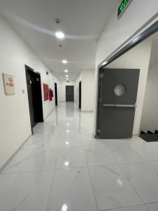 Ar Ruqayyiqahتربل وان للشقق المخدومة的大楼的走廊,有白色的瓷砖地板