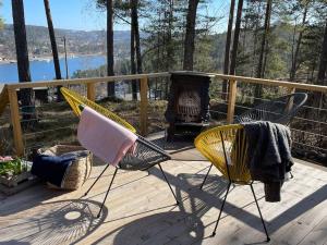 BrevikSummer cabin in Nesodden open-air bath large terrace的一个带两把椅子和壁炉的甲板