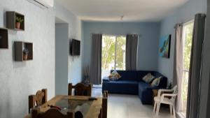 普拉亚卡门Brand new apartment, charming and family-friendly的客厅配有蓝色的沙发和桌子