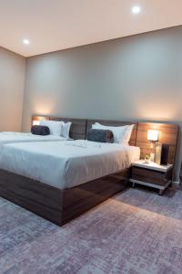 马普托Polana Plaza Hotel的一间卧室配有一张大床和木制床头板