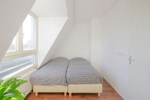 登海尔德De Jutter的白色客房的一张床位,设有窗户