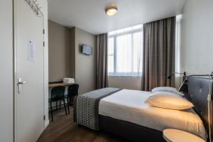 阿姆斯特丹阿科斯塔酒店的配有一张床和一张书桌的酒店客房