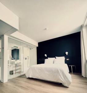 比亚里茨加玛利兹酒店的一间卧室配有一张白色大床和蓝色的墙壁