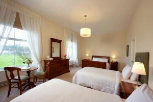 约尔沃尔特罗利酒店的一间卧室设有两张床、一张桌子和一个窗口