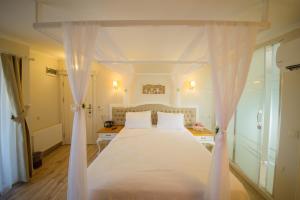 Biga比加帕拉斯酒店的卧室配有白色床和白色窗帘