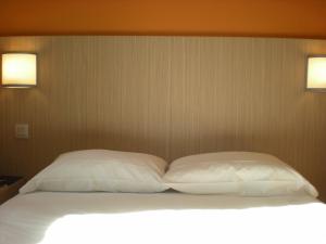 拉贝格拉波格图卢兹萨德普瑞米尔经典酒店的一张带两个白色枕头的床