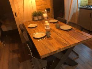 皮滕Kom tot rust op de Veluwe in nieuwe unieke blokhut的一张木桌,上面有盘子和餐具