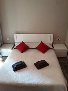 科洛尼奥蒙泽塞Appartamento Piccola Perla的一张带两个红色枕头的白色床