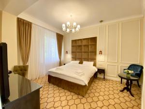 布加勒斯特Venetian Bucharest的酒店客房,配有一张床和吊灯